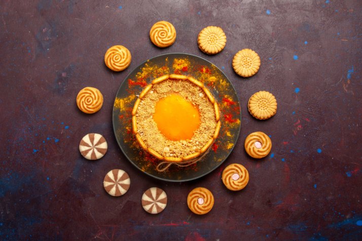 top-view-delicious-yellow-cake-creamy-dessert-with-cookies-dark-surface